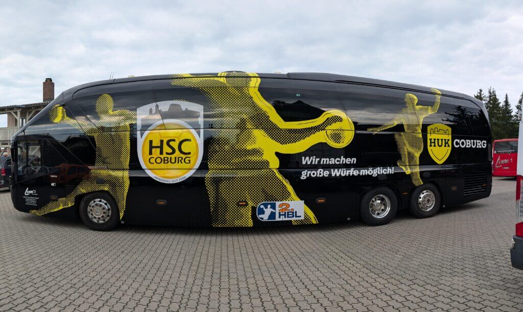 Vollfolierter Mannschaftsbus des HSC 2000 Coburg in Schwarz und Gelb mit Vereinsmotiven