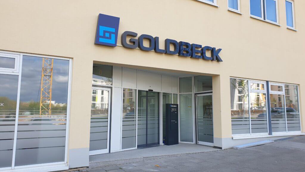 GOLDBECK-Fassadenlogo über dem Eingang eines modernen Gewerbegebäudes