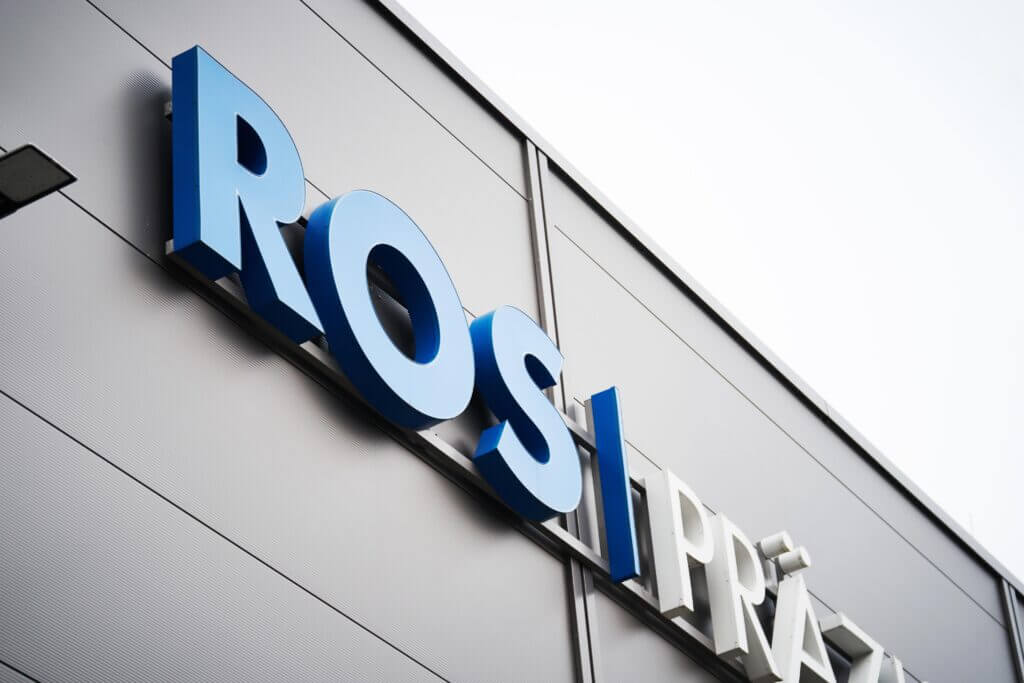 Blau-weiße Rösler-Fassadenbuchstaben auf der grauen Außenwand eines Industriegebäudes