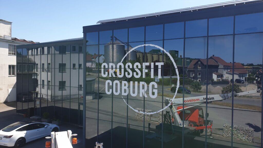 Großflächige Fensterbeschriftung mit CrossFit-Coburg-Logo an einer Glasfassade